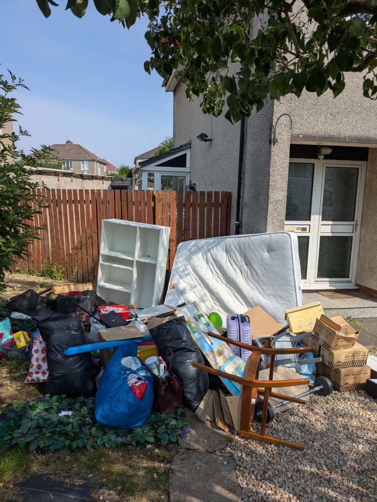 Household items piled outside a Glasgow home waiting to be cleared